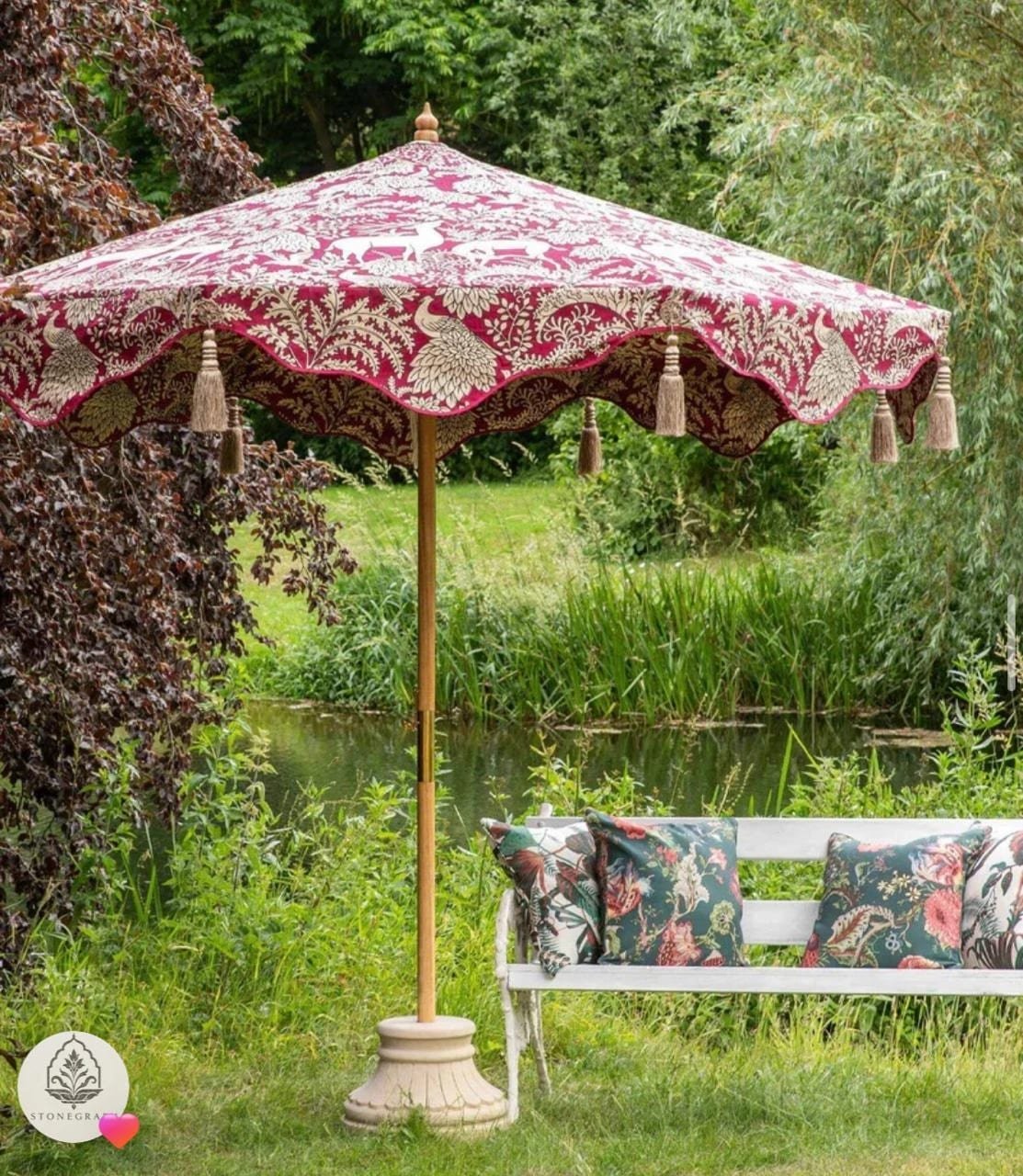 Crimson parasol, by the water — carved in sandstone base